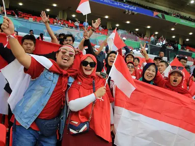 Suporter Indonesia mengibarkan bendera jelang pertandingan sepak bola Grup D Piala Asia antara Indonesia dan Irak di Stadion Ahmad Bin Ali, Al Rayyan, Qatar, Senin (15/1/2024). (AP Photo/Hussein Sayed)