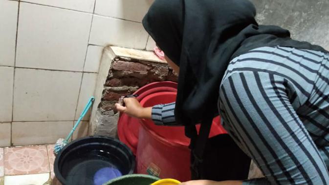Sri Andewi dengan ikhlas berkeliling mencari jentik nyamuk di dalam bak mandi rumah warga di Sumber Kabupaten Cirebon. Foto (Liputan6.com / Panji Prayitno)