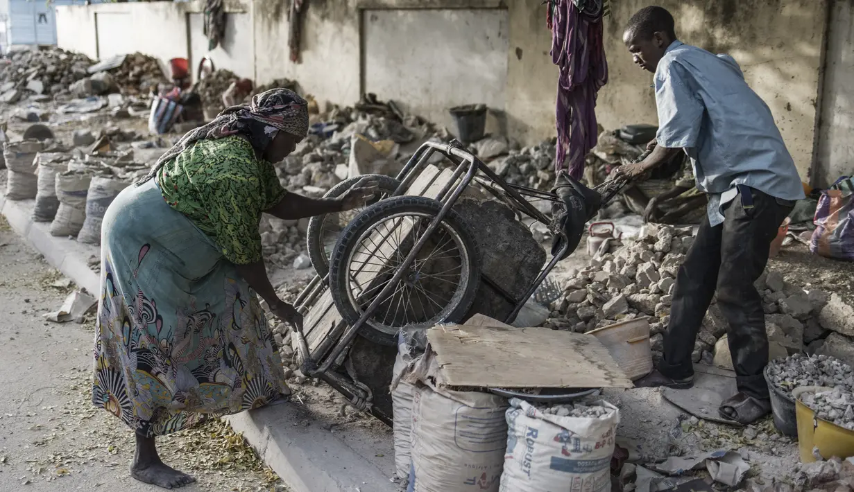 Sebuah gerobak digulingkan dan diguncang untuk melepaskan setiap batu kecil oleh penghancur kerikil di sebuah tempat dekat Cite International des Affaires, N'Djamena, Chad, 12 April 2021. Dalam debu dan panas, wanita Chad menghancurkan kerikil untuk memenuhi kebutuhan. (MARCO LONGARI/AFP)