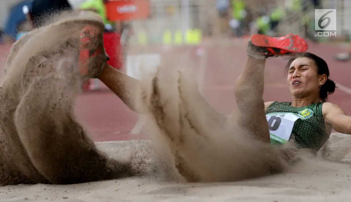 Atlet asal Bali, Maria Londa, melakukan pendaratan saat tampil pada Kejurnas Atletik 2019 nomor lompat jangkit senior di Stadion Pakansari, Bogor pada Rabu (8/8/2019). Kejurnas Atletik berlangsung dari 3 hingga 7 Agustus. (Bola.com/Peksi Cahyo)