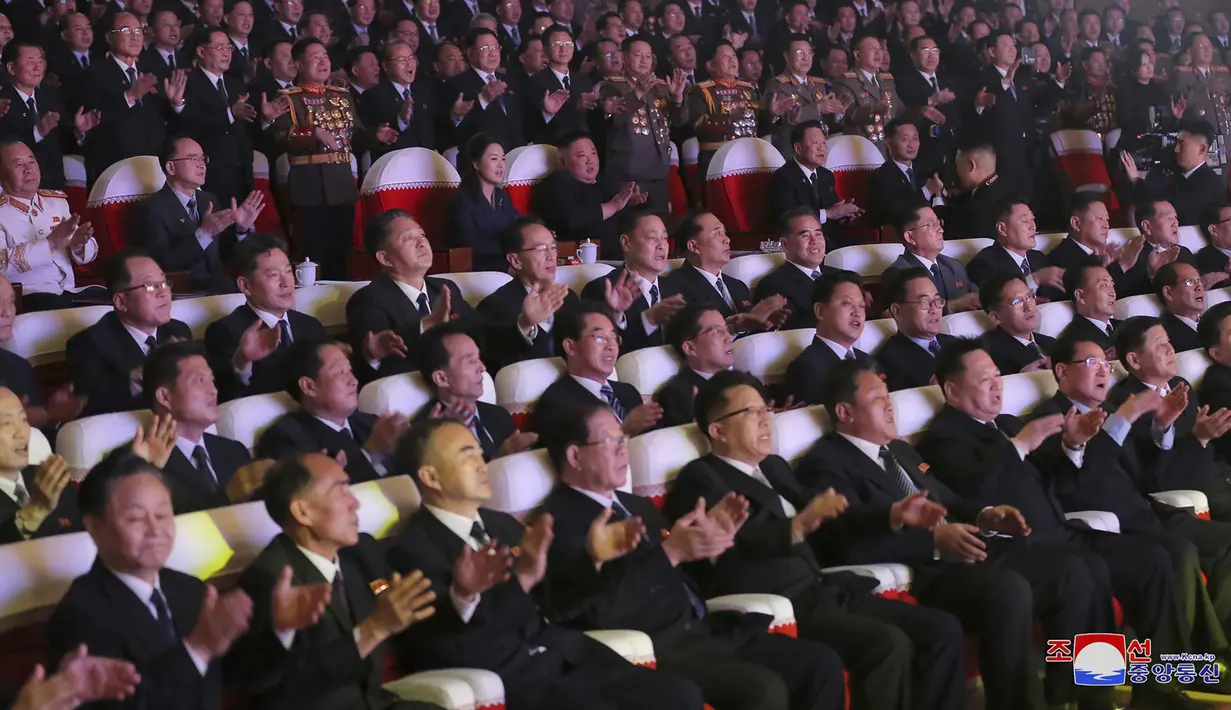 Pemimpin Korea Utara, Kim Jong-un (tengah) bersama istrinya, Ri Sol Ju menonton pertunjukan di Pyongyang pada Selasa (16/2/2021). Dalam foto tersebut, Ri dan Kim Jong-un tampak tersenyum saat mereka menonton konser di Teater Seni Mansudae.  (Korean Central News Agency/Korea News Service via AP)