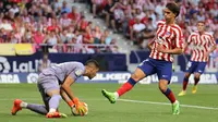 Pemain depan Atletico Madrid  Joao Felix menantang kiper Villarreal Geronimo Rulli (kiri) pada lanjutan Liga Spanyol 2022/2023 di Stadion Wanda Metropolitano, Madrid, Senin (22/8/2022) dini hari WIB. Atletico Madrid menelan kekalahan kandang kala menjamu Villarreal dengan skor 0-2. (Photo by Thomas COEX / AFP)