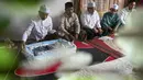 Orang-orang berdoa untuk bayi yang baru lahir saat prosesi aqiqah di Banda Aceh, Aceh, 4 November 2021. Aqiqah adalah tradisi menyambut bayi yang baru lahir dalam agama Islam. (CHAIDEER MAHYUDDIN/AFP)