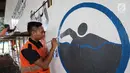 Petugas PPSU Kelurahan Bintaro menggambar mural cabang olahraga renang Asian Games 2018 di kolong Jembatan Layang Tol Bintaro, Jakarta, Senin (13/8). Mural tersebut untuk sosialisasi dan mendukung perhelatan Asian Games. (Liputan6.com/Fery Pradolo)