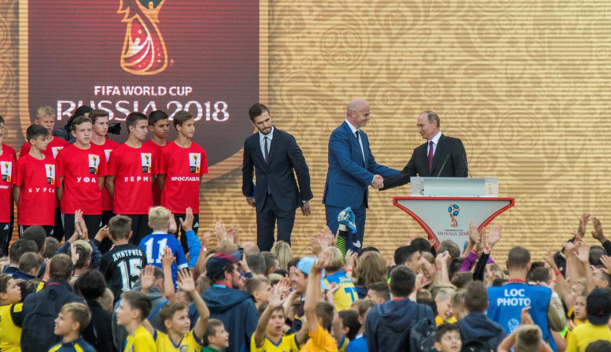 Presiden Rusia Vladimir Putin berjabat tangan dengan Presiden FIFA, Gianni Infantino usai memperlihatkan trofi Piala Dunia dalam pembukaan upacara  "FIFA World Cup Trophy Tour" di stadion Luzhniki di Moskow (9/9). (AFP Photo/Mladen Antonov) 