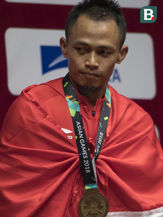 Lifter Indonesia, Suwoto Wijoyo, saat berlaga pada Asian Games di JIExpo, Jakarta, Senin, (20/8/2018). Suwoto Wijoyo berhasil menyumbang medali perunggu angkat besi putra kelas 56kg. (Bola.com/Vitalis Yogi Trisna)