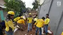 Petugas dibantu alat berat membersihkan puing longsoran di Perumahan Pesona Kalisari, Pasar Rebo, Jakarta, Selasa (27/11). Sebelumnya, rumah milik ketua RT setempat terkena longsor pada Senin (26/11) karena hujan deras. (Liputan6.com/Herman Zakharia)