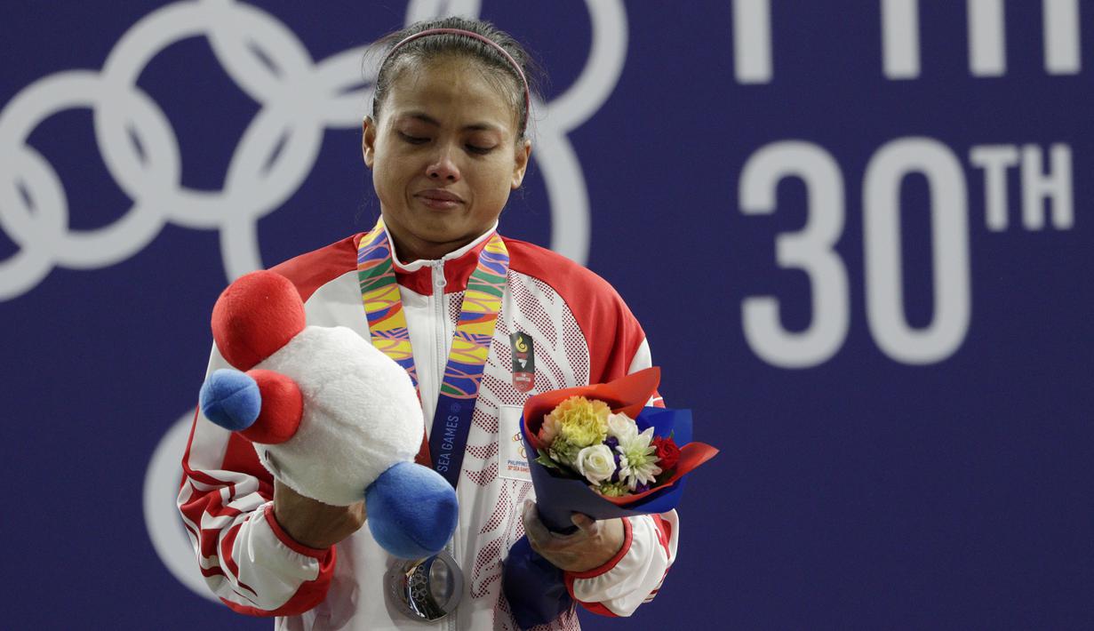 Lifter Lisa Setiawati saat naik podium usai mendapatkan medali perak SEA Games 2019 cabang angkat besi nomor 45 kg di Stadion Rizal Memorial, Manila, Minggu (1/12). Dirinya meraih perak dengan total angkatan 169 kg. (Bola.com/M Iqbal Ichsan)