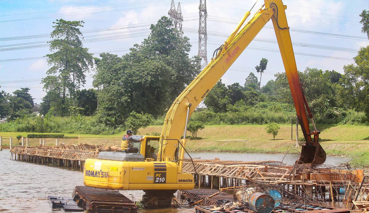 Pemerintah Kota Depok memastikan pembangunan tersebut tidak memiliki izin resmi. Tampak dalam foto, petugas Dinas Sumber Daya Air Pemerintah Provinsi Jawa Barat membongkar tiang pancang beton yang dipasang di Setu Tujuh Muara, Sawangan, Depok, Senin (16/01/2026). (Merdeka.com/Arie Basuki)