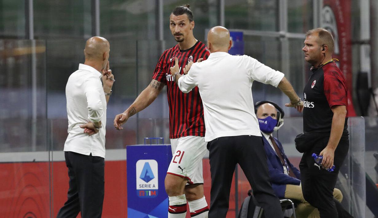 Pelatih AC Milan, Stefano Pioli, berusaha menenangkan Zlatan Ibrahimovic yang kecewa usai diganti saat melawan Bologna pada laga Serie A di Stadion San Siro, Sabtu (18/7/2020). AC Milan menang dengan 5-1 atas Bologna. (AP/Luca Bruno)