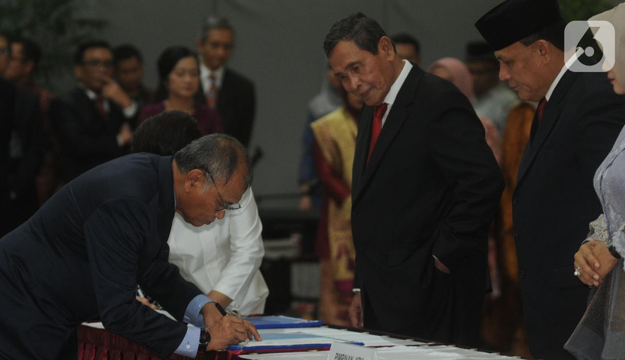 Ketua KPK periode 2015-2019 Agus Rahardjo (kiri) menandatangani nota serah terima jabatan disaksikan Ketua KPK Firli Bahuri (kanan) saat pisah sambut usai pelantikan di Gedung KPK, Jakarta, Jumat (20/12/2019). Acara ini dihadiri pimpindan dan Dewan Pengawas KPK. (merdeka.com/Dwi Narwoko)