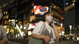 Seorang wanita mengenakan masker melintasi persimpangan di distrik perbelanjaan Ginza Tokyo, Kamis (23/9/2021). Di tempat ini terdapat berbagai toko serba ada, butik, restoran dan kafe. (AP Photo/Hiro Komae)