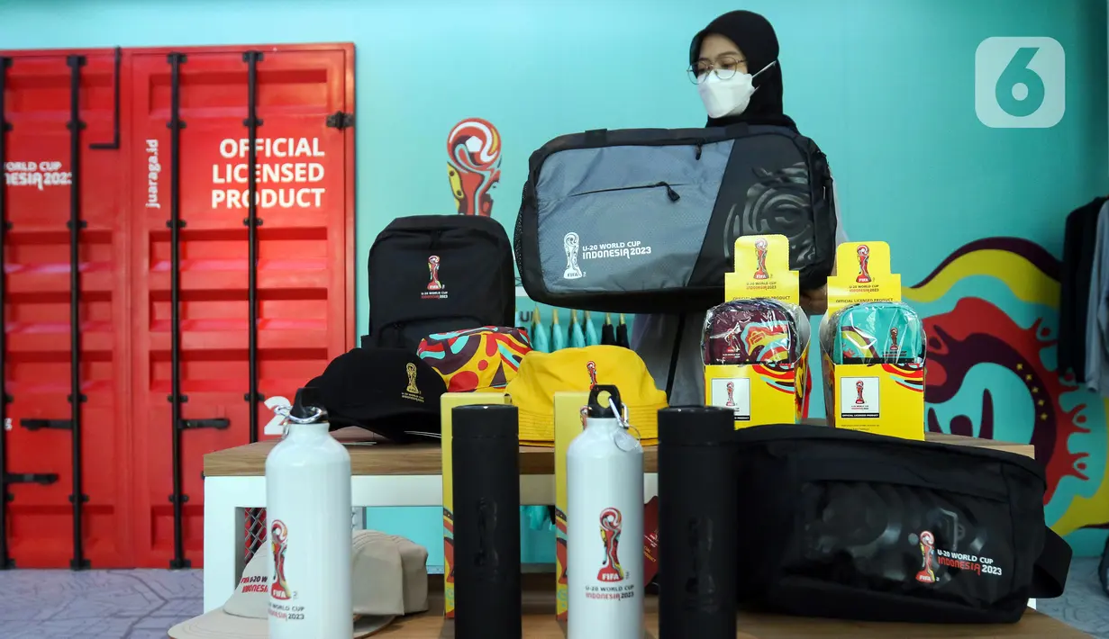 Petugas merapikan merchandise Piala Dunia U-20 2023 di Jakarta, Kamis (30/3/2023). PT. Juara Raga Adidaya (Juaraga) selaku pemegang lisensi merchandise untuk Piala Dunia U-20 2023 merasakan dampak besar dari pencoretan Indonesia sebagai tuan rumah, dikarenakan Juaraga telah memproduksi 53 jenis merchandise. (Liputan6.com/Herman Zakharia)