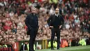 Aksi pelatih Manchester United, Jose Mourinho (kiri) dan pelatih  Manchester City, Pep Guardiola (R) saat menyaksikan anak asuhnya berlaga pada laga Premier League di Old Trafford, Manchester,  (10/9/2016). (AFP/Oli Scarff)