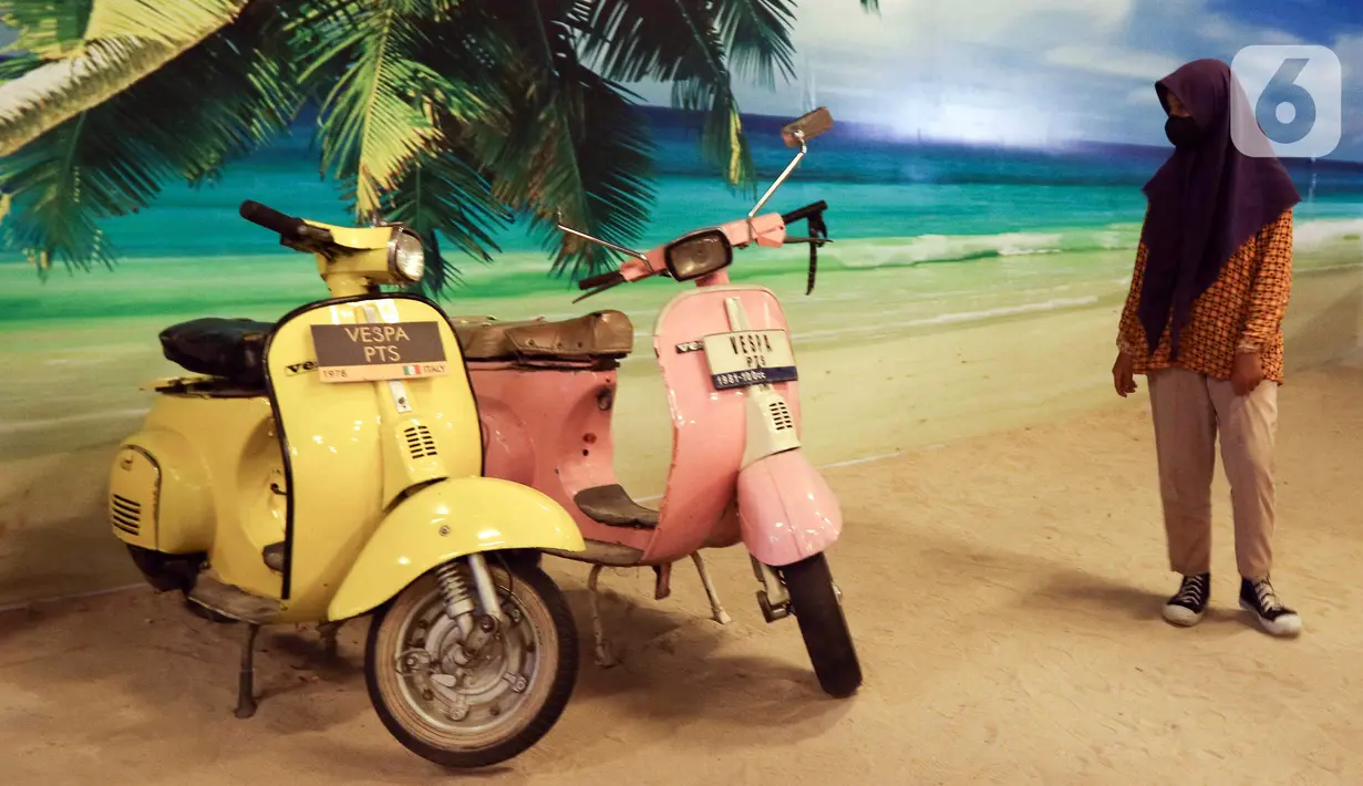 Pengunjung melihat motor antik yang dipamerkan di Museum Angkut, Kota Batu, Jawa Timur, Kamis (15/12/2022). Museum Angkut memiliki lebih dari 300 koleksi jenis angkutan tradisional hingga modern. (Liputan6.com/Herman Zakharia)