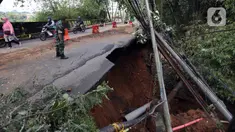 Seorang tentara melihat kondisi longsor di kawasan Jembatan Darul Qur’an, Jalan KH. Tb. M. Falak, Kecamatan Bogor Barat, Kota Bogor, Jawa Barat, Rabu (12/10/2022). Longsor yang terjadi pada kemarin sore saat hujan deras menyebabkan jalan utama yang menghubungkan Jalan Semeru dengan Jalan Raya Loji-Gunung Batu kini hanya dapat dilalui sepeda motor. (merdeka.com/Arie Basuki)