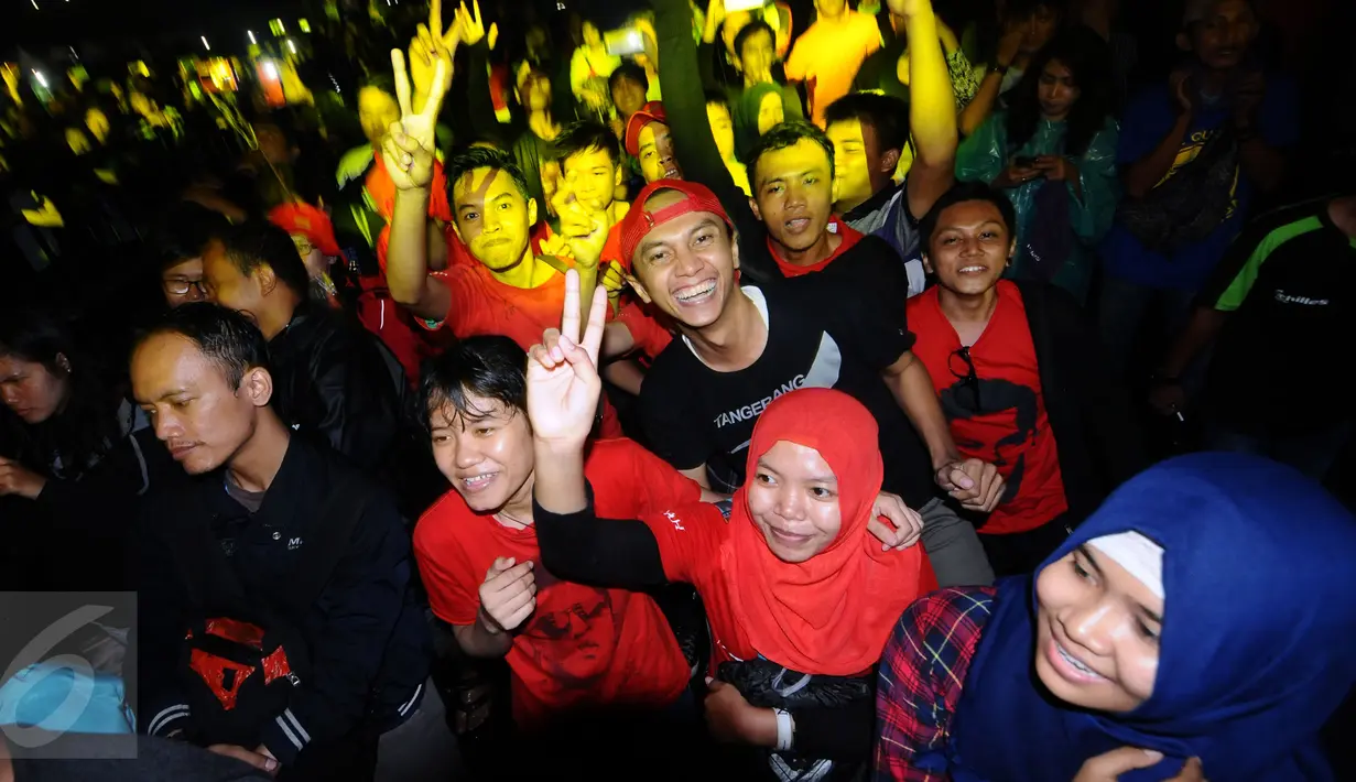 Para sahabat NOAH melompat lompat mengikuti irama musik saat menyaksikan penampilan Ariel dkk usai perhelatan Achilles Motorsport Festival 2015 di JIExpo Kemayoran Jakarta, Sabtu (19/12/2015). (Liputan6.com/Helmi Fithriansyah)