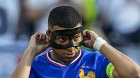 Pemain Prancis, Kylian Mbappe dengan mengenakan topeng saat menghadapi Polandia di fase Grup Euro 2024. (AP Photo/Darko Vojinovic)