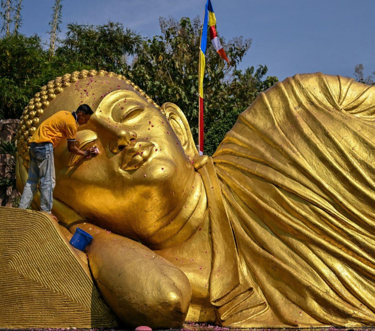 Pengurus memandikan patung Buddha Maha Paranibbana, yang biasa disebut Buddha Tidur, di&nbsp;Maha Vihara Mojopahit, Mojokerto, Jawa Timur, pada Rabu (16/5/2024). Pembersihan patung Buddha Tidur ini dilakukan menjelang perayaan Hari Raya Waisak, pada 23 Me