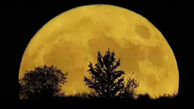 Supermoon terbit di balik bukit di Pera Chorio Nisou, pinggiran Nicosia, Siprus, Selasa, 1 Agustus 2023. (AP Photo/Petros Karadjias)