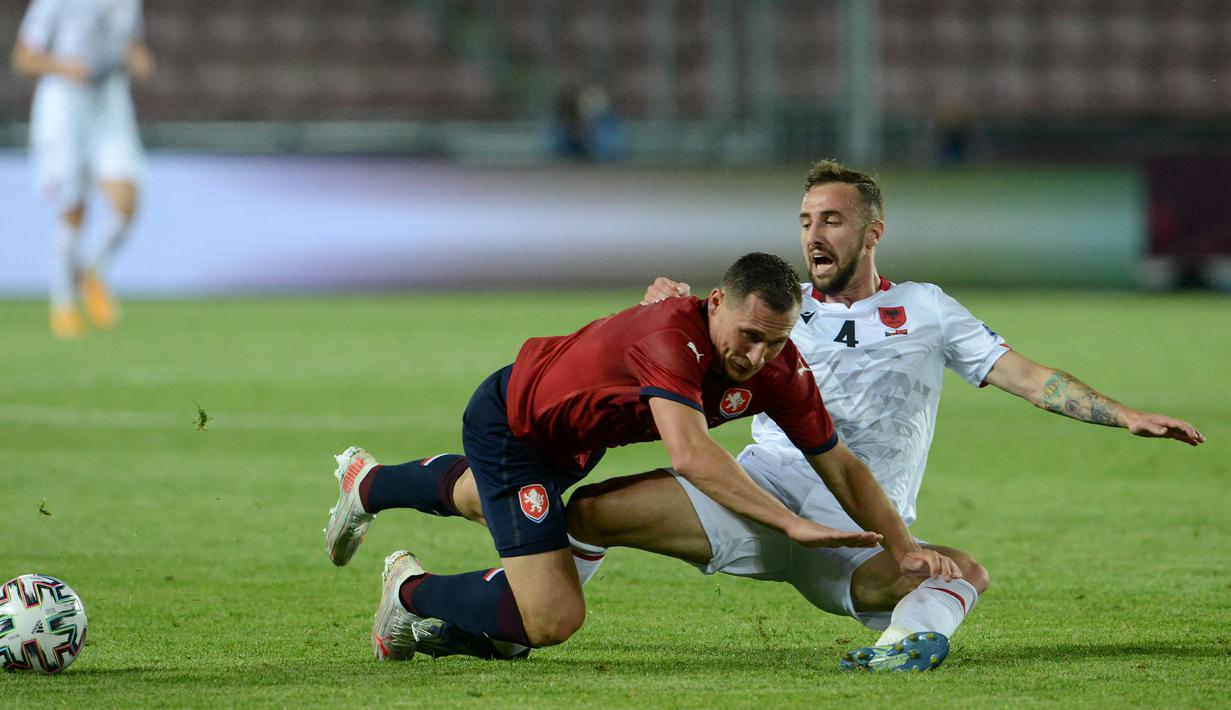 Bek Republik Ceska, Jan Boril (kiri) dan gelandang Albania, Endri Cekici terjatuh saat perebutan bola dalam laga uji coba menjelang Euro 2020 di Praha, Republik Ceska, Selasa (8/6/2021). Republik Ceska menang 3-1 atas Albania. (AFP/Michal Cizek)