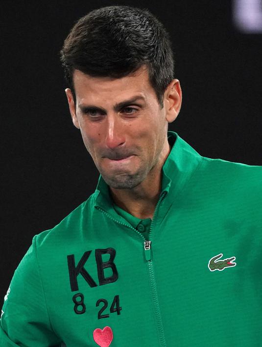 Reaksi Novak Djokovic saat diwawancarai tentang kematian Kobe Bryant usai mengalahkan Milos Raonic pada perempat final Australia Terbuka di Melbourne, Selasa (28/1/2020). Djokovic mengenakan jaket dengan inisial dan nomor punggung Kobe Bryant untuk menghormati temannya itu. (AP Photo/Lee Jin-man)