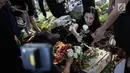 Kekasih almarhum Andika Putra Sahadewa, Nicky Santoso menaruh mawar di makam di TPU Sunan Giri, Rawamangun, Jakarta, Selasa (10/9). Bassist grup band Kerispatih, Andika Putra Sahadewa, meninggal dunia di usia 36 tahun. (Liputan6.com/Faizal Fanani)