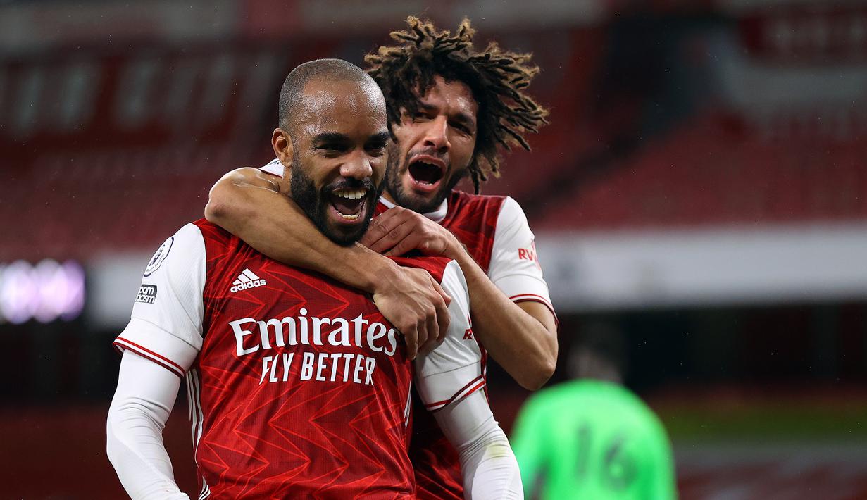 Striker Arsenal, Alexander Lacazette (kiri), melakukan selebrasi bersama Mohamed Elneny usai mencetak gol lewat eksekusi penalti dalam laga lanjutan Liga Inggris 2020/21 pekan ke-15 di Emirates Stadium, London, Sabtu (26/12/2020). Arsenal menang 3-1 atas Chelsea. (AFP/Julian Finney/Pool)
