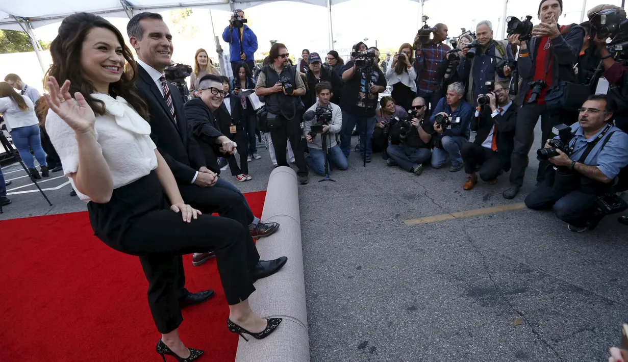 Walikota Los Angeles, Eric Garcetti bersama aktris Katie Lowes (kiri) dan Lea DeLaria secara simbolis menggelar karpet merah saat persiapan Screen Actors Guild Awards 2016 di Shrine Auditorium, Los Angeles, Jumat (29/1). (REUTERS/Mario Anzuoni)