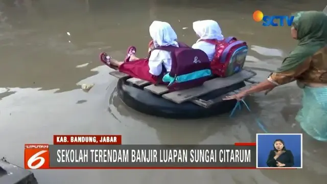 Banjir yang menerjang kawasan Kabupaten Bandung belum juga surut. Siswa SD terpaksa berangkat sekolah menggunakan rakit dari ban bekas.