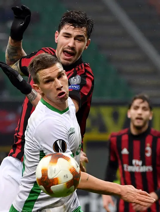 Pemain AC Milan, Alessio Romagnoli dan pemain Ludogorets, Jakub Swierczok berebut bola pada leg kedua babak 32 besar Liga Europa di San Siro, Milan, Kamis (22/2). Milan menang tipis 1-0 sehingga lolos ke babak 16 besar. (Daniel Dal Zennaro/ANSA via AP)