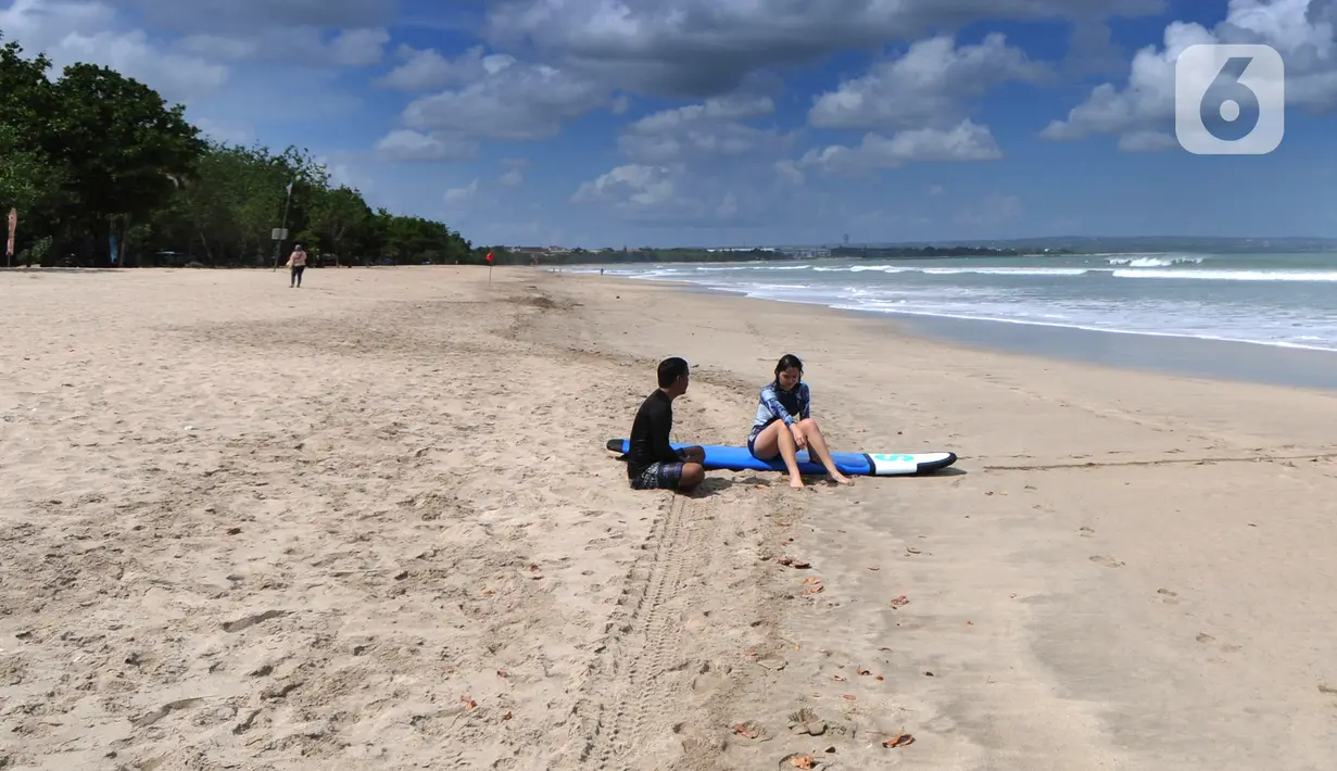 <p>Wisatawan usai bermain selancar di kawasan Pantai Kuta, Bali, Jumat (3/9/2021). Sepinya wisatawan yang datang ke Pulau Bali selama PPKM Darurat yakni hanya sebesar rata-rata 500 wisatawan lokal menyebabkan sejumlah tempat wisata pantai sepi pengunjung. (merdeka.com/Arie Basuki)</p>