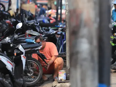 Sejumlah mekanik memperbaiki motor di salah satu bengkel di Otista, Jakarta, Minggu (10/6). Calon pemudik motor mulai memenuhi bengkel guna menyervis atau mengganti suku cadang kendaraan sebelum digunakan untuk mudik Lebaran. (Liputan6.com/Angga Yuniar)