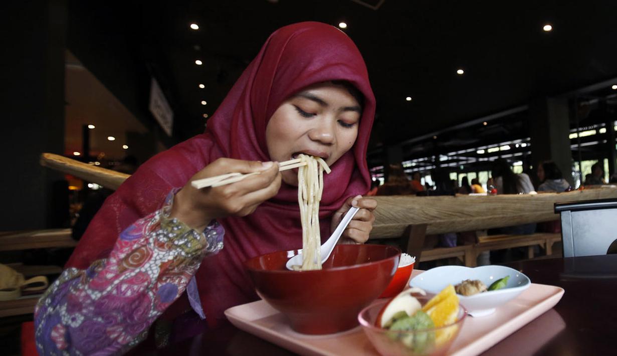 Tanpa ragu-ragu, Cahyani Ariya Wiji, (mahasiswa muslim asal Indonesia) menyantap semangkuk mie Udon halal, di Kanda University of International Studies di Chiba, sebelah timur Tokyo, foto diambil 13 Mei 2014 lalu. (REUTERS/Yuya Shino)