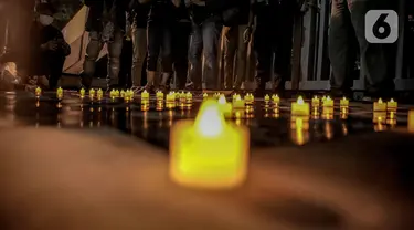 Lilin-lilin menyala dalam aksi solidaritas untuk rakyat Myanmar oleh sejumlah aktivis di depan Kantor ASEAN, Jakarta, Jumat (12/3/2021). Dalam aksi tersebut aktivis memberikan dukungan kepada korban kekerasan yang terjadi akibat kudeta militer di Myanmar. (Liputan6.com/Faizal Fanani)