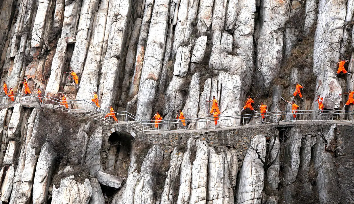 Sejumlah murid kungfu shaolin melakukan gerakan berbahaya diatas tebing gunung  Songshan, , China , (17/3). Dengan berpakaian kungfu dan senjata lengkap mereka berlatih dengan kompak. (REUTERS / China Daily)