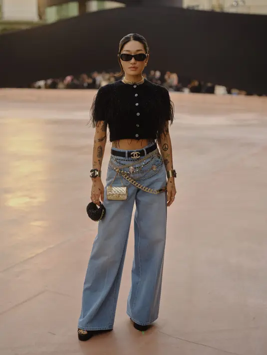 Peggy Gou tampil swag dengan cropped ripped tweed blazer Chanel hitam. DIpadu dengan baggy light jeans dan aksesori ikat pinggang dan rantai yang meriah. [Chanel]