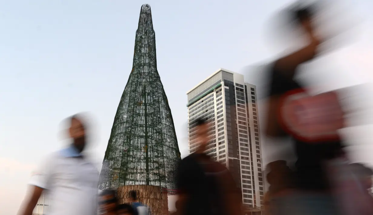 Sri Lanka telah memecahkan rekor dunia pohon Natal tertinggi, Sri Lanka, Sabtu (24/12). Atlet kriket terkenal Sri Lanka, Arjuna Ranatunga adalah orang di balik pembuatan pohon Natal raksasa tersebut. (AFP PHOTO / Lakruwan Wanniarachchi)