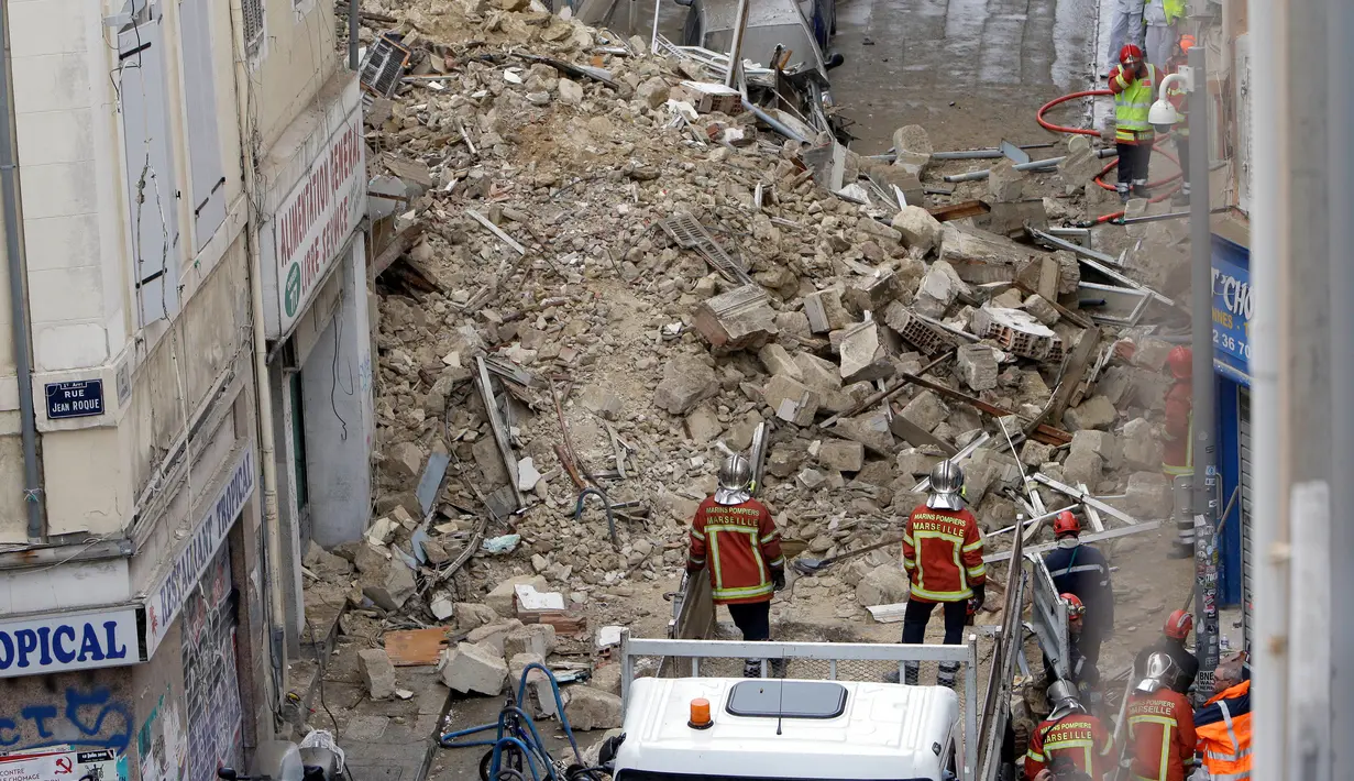 Petugas pemadam kebakaran berada dekat bangunan yang runtuh di Marseille, Prancis, Senin (5/11). Wali Kota Marseille Sabine Bernasconi meminta, seluruh warga untuk dipindahkan dari bangunan yang tengah dalam renovasi tersebut. (AP/Claude Paris)