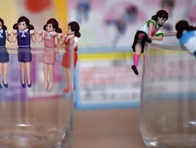 Sejumlah mainan berkarakter wanita mengenakan pakaian kantor menggantung di gelas kaca yang dipamerkan produsen Kitan Club, Tokyo (15/11). Mainan kecil atau yang biasa disebut "orang-orangan" ini telah ada lebih dari 40 tahun. (AFP Photo/Kazuhiro Nogi)