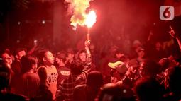 Seorang pengunjuk rasa menyalakan flare saat aksi menolak kenaikan harga BBM bersubdisi di kawasan Patung Kuda Arjuna Wijaya, Jakarta, Selasa (13/9/2022). Aksi unjuk rasa yang menolak kenaikan harga BBM bertahan hingga malam hari di kawasan tersebut. (Liputan6.com/Faizal Fanani)
