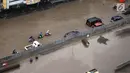 Pengendara sepeda motor mendorong kendaraannya akibat banjir di Jalan Boulevard Barat Raya, Kelapa Gading, Jakarta Utara, Kamis (15/2). Hujan lebat mengakibatkan kawasan tersebut kebanjiran. (Liputan6.com/Arya Manggala)