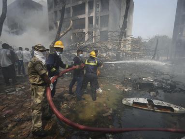 Petugas pemadam kebakaran bekerja di lokasi jatuhnya pesawat di kota Ahmedabad, negara bagian Gujarat, India Barat Laut, Kamis 12 Juni 2025. (AP/Ajit Solanki)