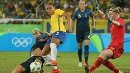 Pemain Brasil Thaisa (tengah) saat melewati hadangan pemain Swedia pada lanjutan sepak bola wanita di Olimpiade Rio 2016,Brasil, (6/8). Empat puluh tiga ribu suporter bergemuruh saat kesebelasan Brasil menang telak. (REUTERS / Gonzalo Fuentes)