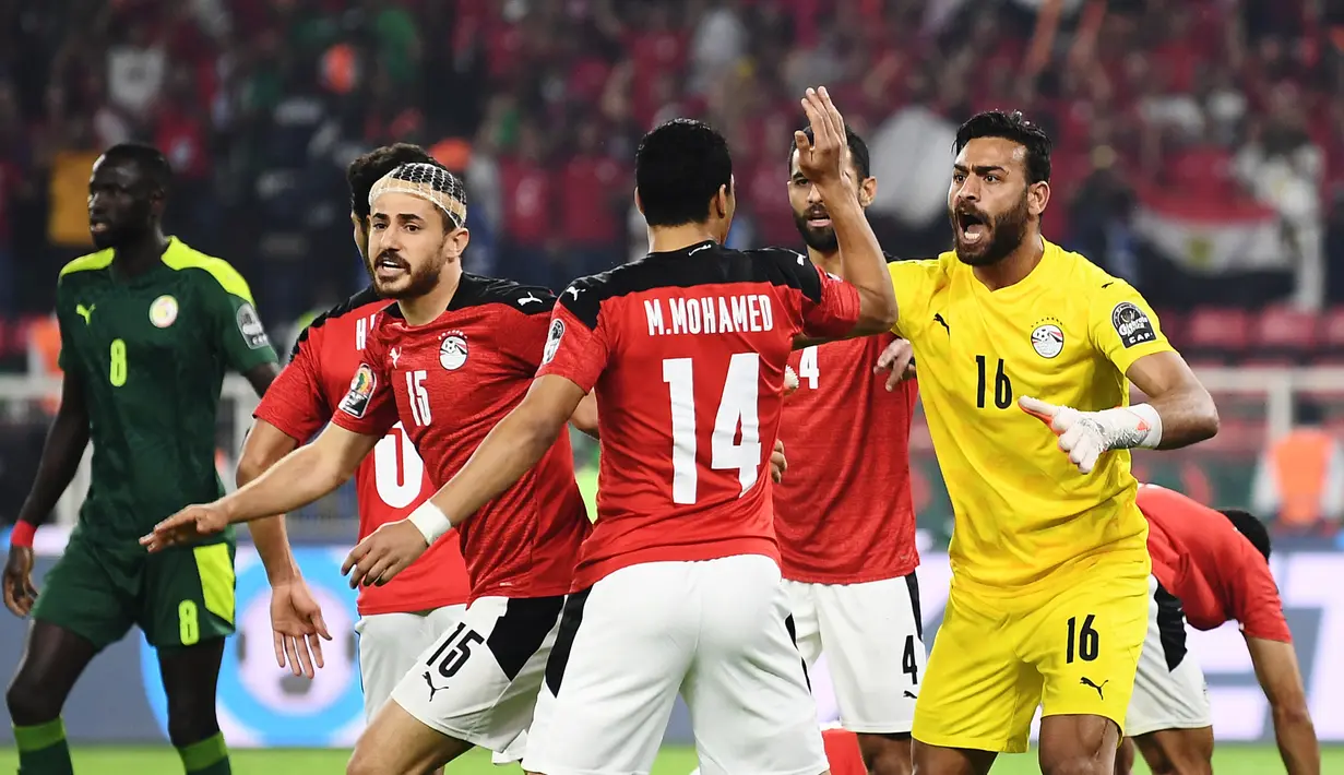 Kiper Mesir, Mohamed Abogabal (kanan) bersama rekan setim merayakan keberhasilan menggagalkan tendangan penalti striker Senegal, Sadio Mane dalam laga final Piala Afrika 2021 di Stade d'Olembe, Yaounde, Kamerun (6/2/2022). (AFP/Kenzo Tribouillard)