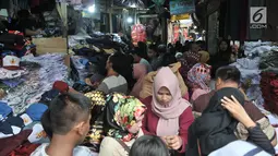 Keramaian saat para para orangtua mencari seragam sekolah di Pasar Jatinegara, Jakarta, Minggu (14/7/2019). Jelang tahun ajaran baru, Pasar Jatinegara ramai didatangi para orangtua yang mencari seragam sekolah untuk anaknya. (merdeka.com/Iqbal Nugroho)