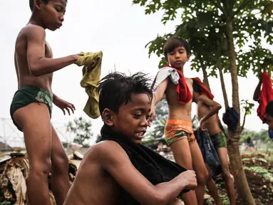 Seorang anak mencari biawak di tepi Sungai Banjir Kanal Barat, Petamburan, Jakarta, Jumat (9/11). Mendung yang menyelimuti ibukota Jakarta, tidak menyurutkan anak-anak bermain di Sungai Banjir Kanal Barat. (Liputan6.com/Fery Pradolo)