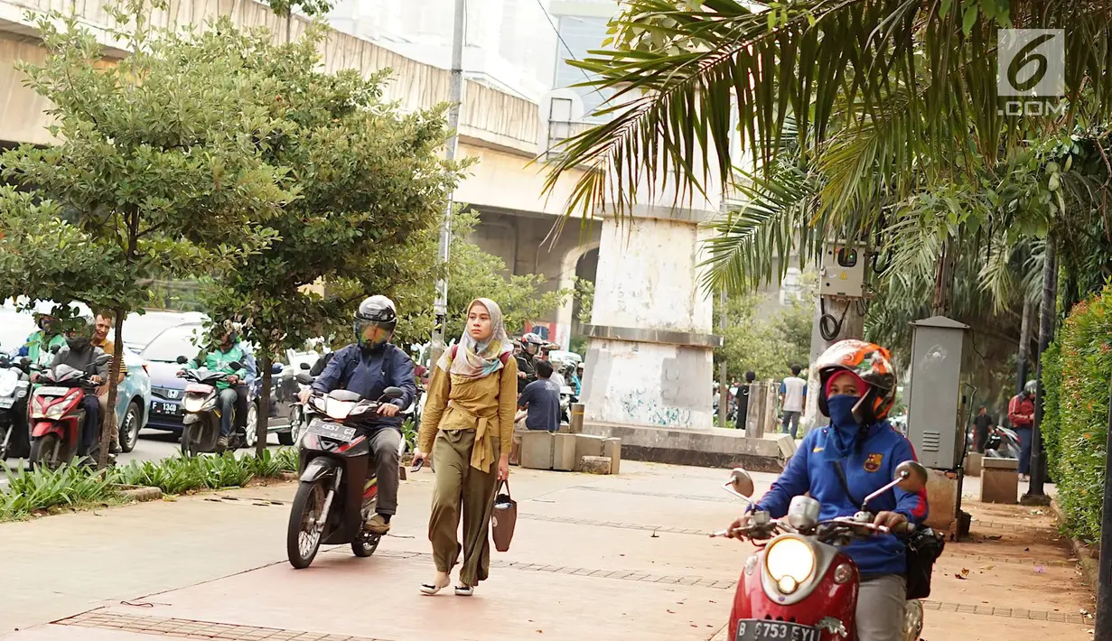Pengendara sepeda motor melintasi trotoar di kawasan Menteng Pulo, Jakarta, Selasa (14/5/2019). Kemacetan yang semakin parah di Ibu Kota menyebabkan para pemotor nekat menerobos trotoar dan merampas hak pejalan kaki. (Liputan6.com/Immanuel Antonius)