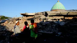 Warga melihat reruntuhan bangunan Masjid Jamiul Jamaah yang rusak akibat gempa bumi di Bangsal, Lombok Utara, Rabu (8/8). Berdasarkan kesaksian warga, diduga puluhan korban yang sedang melaksanakan pengajian tertimbun bangunan masjid. (AP/Tatan Syuflana)