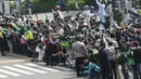 Warga saat melihat parade pembalap MotoGP di depan Sarinah Thamrin, Jakarta Pusat. Sebanyak 20 pembalap melakukan parade motor dari Istana Merdeka menuju Hotel Kempinski di Bundaran HI Jakarta Pusat, Rabu (16/03/2022). (Bola.com/M Iqbal Ichsan)